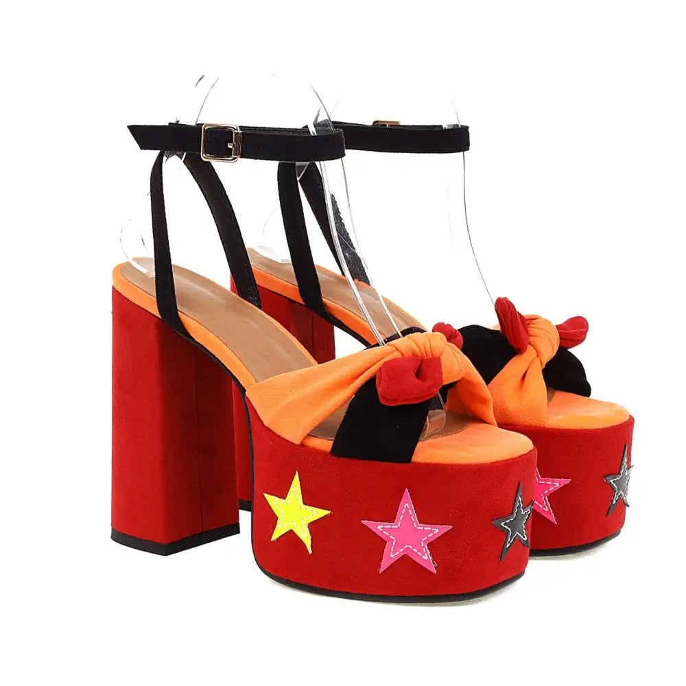 Red star appliqué chunky high heel platform sandals in red with black straps orange bows and colorful star appliqués