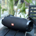 Black wireless bluetooth speaker with textured fabric strap and glossy plastic ends for bluetooth audio use
