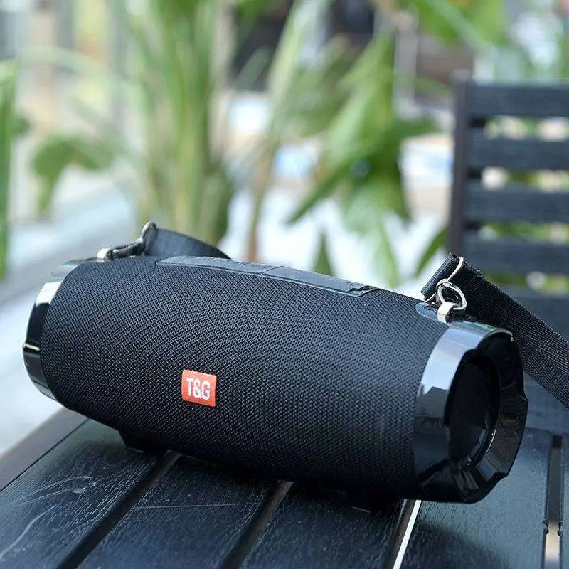 Black wireless bluetooth speaker with textured fabric strap and glossy plastic ends for bluetooth audio use