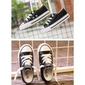 Black canvas low-top sneakers with white rubber soles and toe caps for casual shoes student and children’s clothing