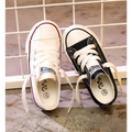 A pair of red toddler canvas casual shoes student style with one white and one black sneaker featuring branded labels