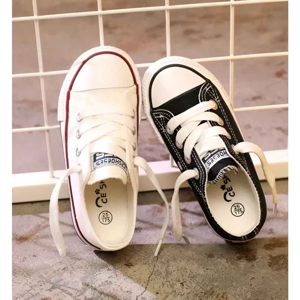 A pair of red toddler canvas casual shoes student style with one white and one black sneaker featuring branded labels