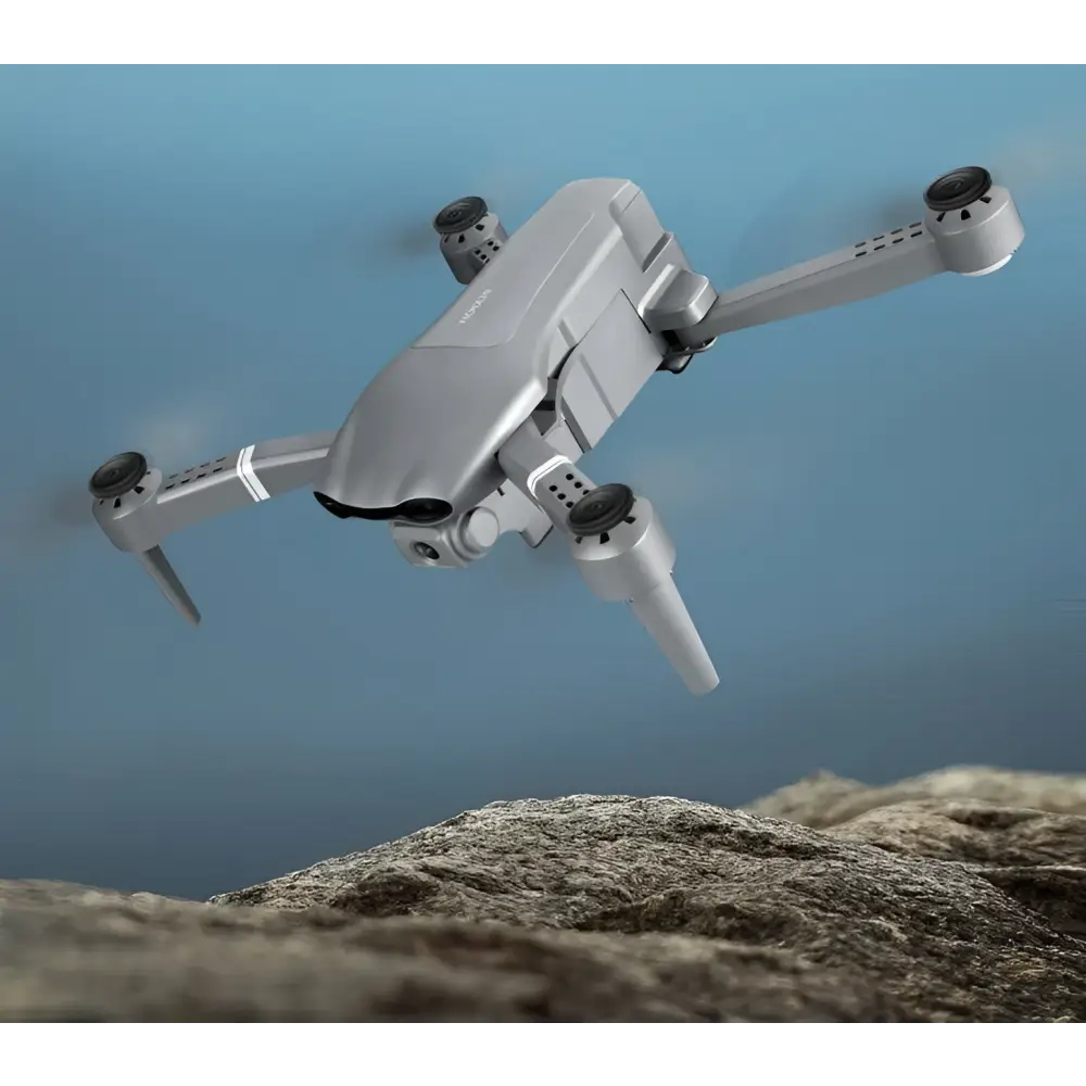 Silver gray folding drone with sleek design and black propeller guards featuring mobile phone control and gps positioning