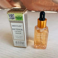 Golden dropper bottle of breylee retinol skin firming serum with amber liquid beside matching box for fine lines