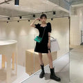 Green crocodile-textured crossbody bag with chain strap paired with retro black satin v neck puff sleeve dress