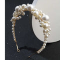 A delicate gold-toned retro bridal headdress featuring a simple pearl headband with cream and white pearls intricately woven