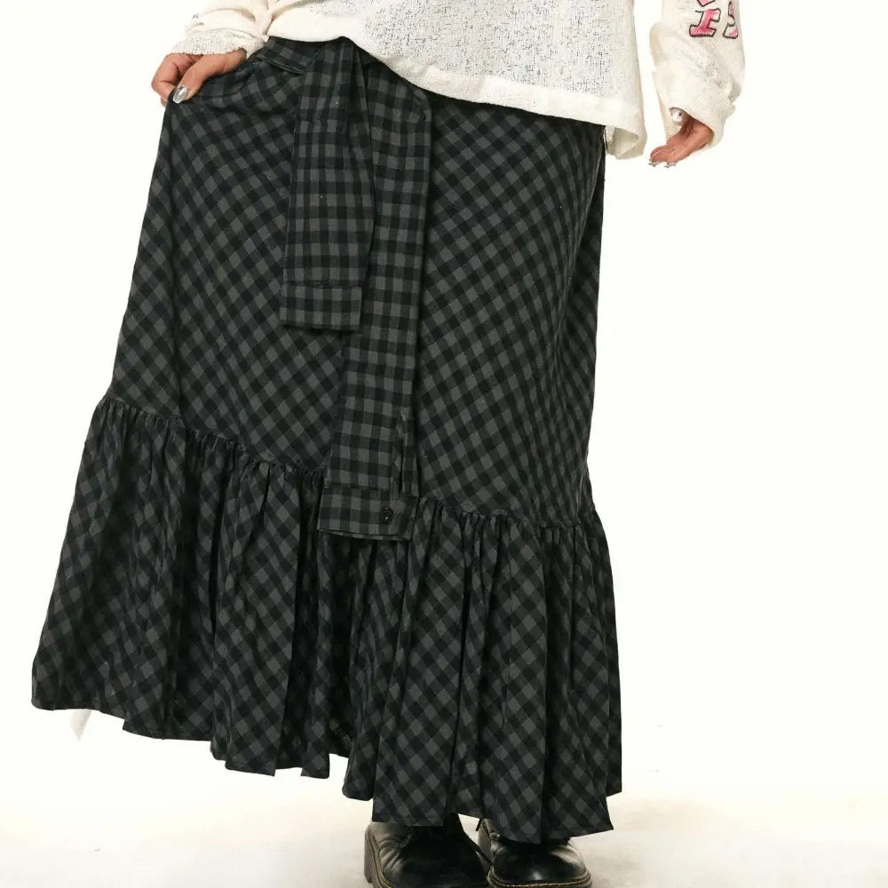A black and gray checkered fishtail skirt with a matching ruffled plaid design and a belt tied at the waist