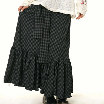 A black and gray checkered fishtail skirt with a matching ruffled plaid design and a belt tied at the waist