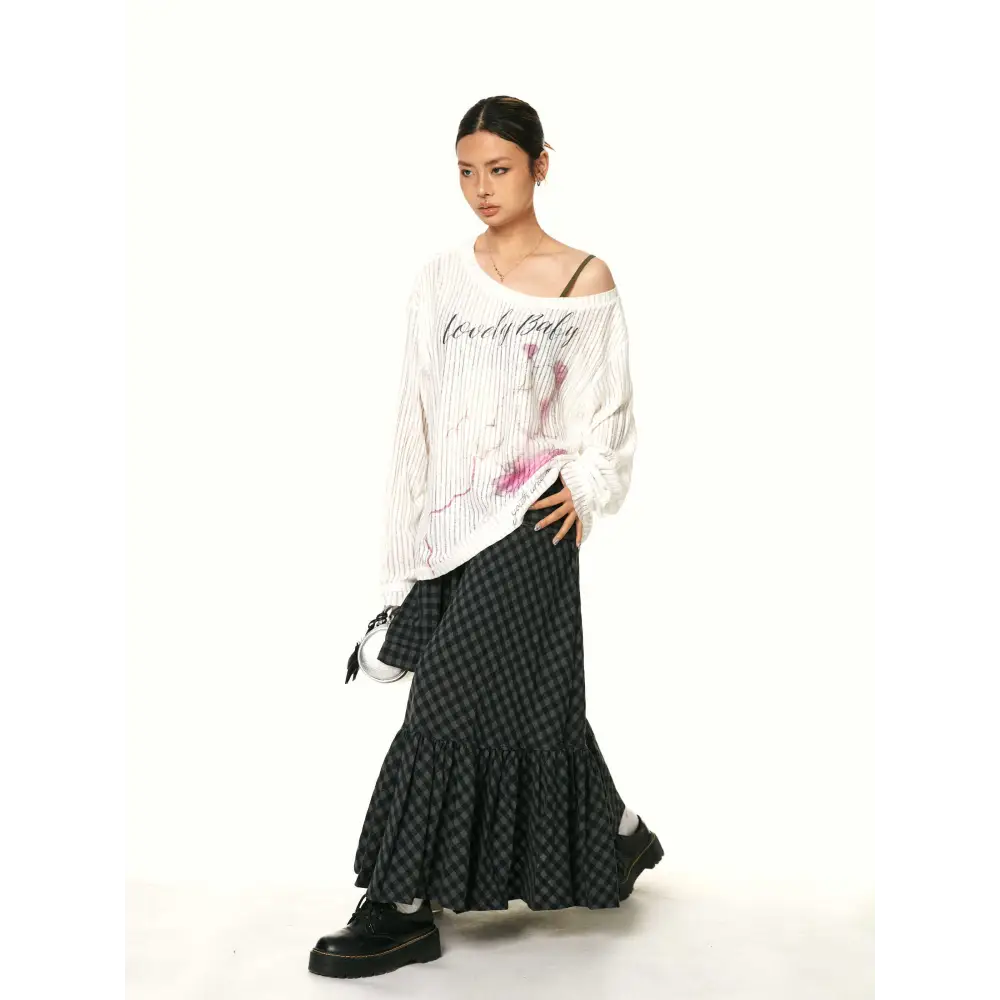 A black and gray checkered fishtail skirt with a matching ruffled plaid design and a belt tied at the waist
