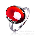 A striking s925 sterling silver ring with a large oval retro red zircon in an ornate floral silver jewelry set design