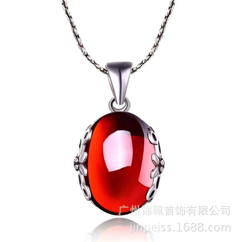A vibrant red oval retro red zircon pendant with intricate s925 sterling silver filigree on a matching silver jewelry set chain