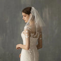 A retro short wedding lace floral veil in sheer white with delicate embroidery as a wedding bride headdress