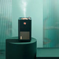 Black rectangular retro vinyl navy blue single spray humidifier with orange button and silver lid emitting mist
