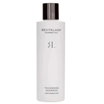 A sleek white bottle of revitalash cosmetics thickening shampoo with a glossy black cap for scalp therapy