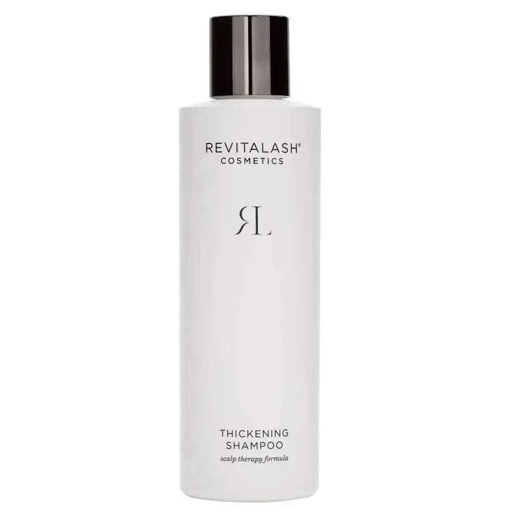A sleek white bottle of revitalash cosmetics thickening shampoo with a glossy black cap for scalp therapy
