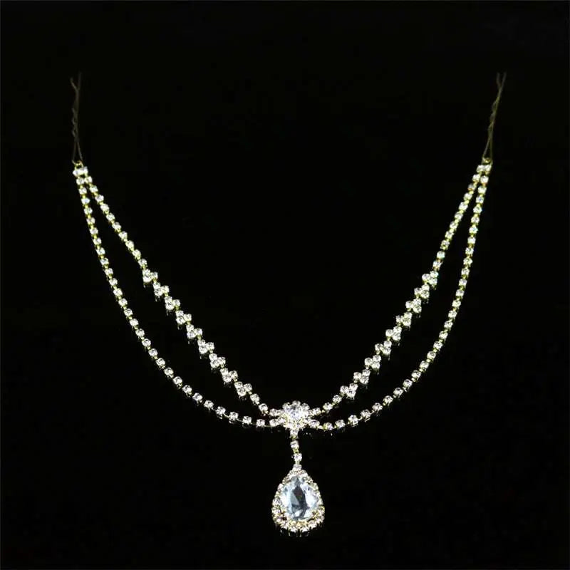 A gold-toned drop bridal chain with sparkling clear crystals and a teardrop pendant for bridal or silver rhinestone headdress use