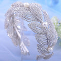 A silver rhinestone leaf handmade headband with clear rhinestones and three white pearls for bridal wear