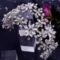 A silver rhinestone leaf handmade headband adorned with clear faceted crystals in floral and leaf patterns for bridal use