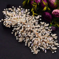 A sparkling gold rhinestone leaf handmade bridal headband adorned with clear crystals, pearls, and intricate leaves