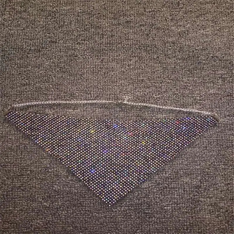A triangular black mesh face mask with densely packed sparkling rhinestones and a delicate silver chain from rhinestone metal flash