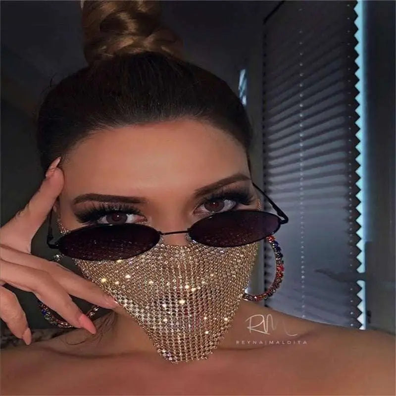 A sparkling gold rhinestone metal flash mesh face mask worn over the nose and mouth area for stylish protection