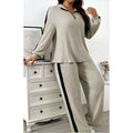 Beige ribbed knit two-piece loungewear set featuring wide leg pants with black side stripes and ribbed knit striped detail