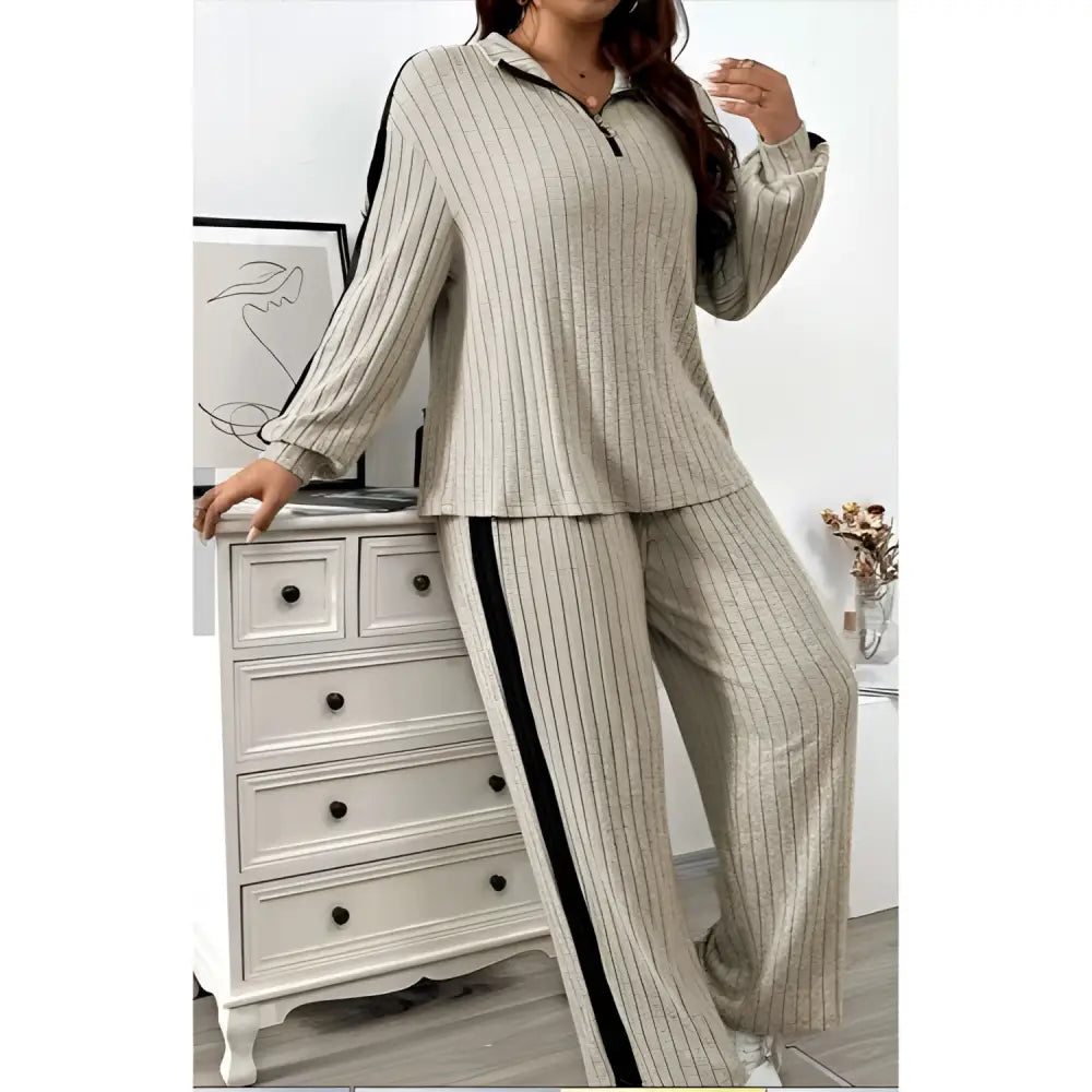 Beige ribbed knit two-piece loungewear set featuring wide leg pants with black side stripes and ribbed knit striped detail