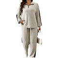 A beige ribbed knit two-piece loungewear set featuring ribbed knit striped wide leg pants with black side panels