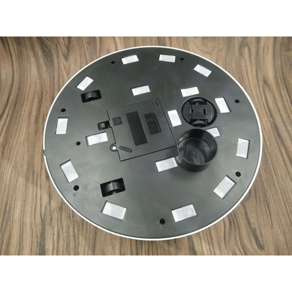 Black circular robot household automatic sweeping machine base with white trim and reflective rectangular stickers