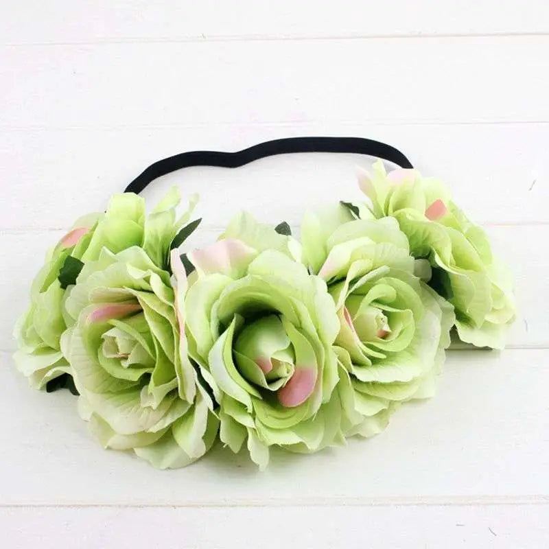 A delicate blue floral rose headband with soft green and pink artificial roses and a black elastic band rose color package