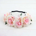 A delicate floral rose headband from the rose color package with pink cream roses green leaves and a black elastic band