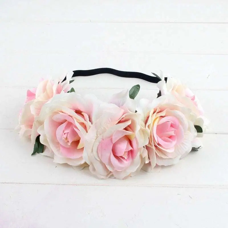 A delicate floral rose headband from the rose color package with pink cream roses green leaves and a black elastic band