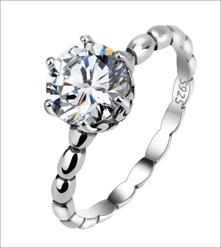Rose gold beaded sterling silver ring with a round-cut clear gemstone set in four prongs and ornate band