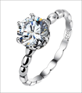 Rose gold beaded sterling silver ring with a large round-cut clear gemstone in a six-prong setting silver ring