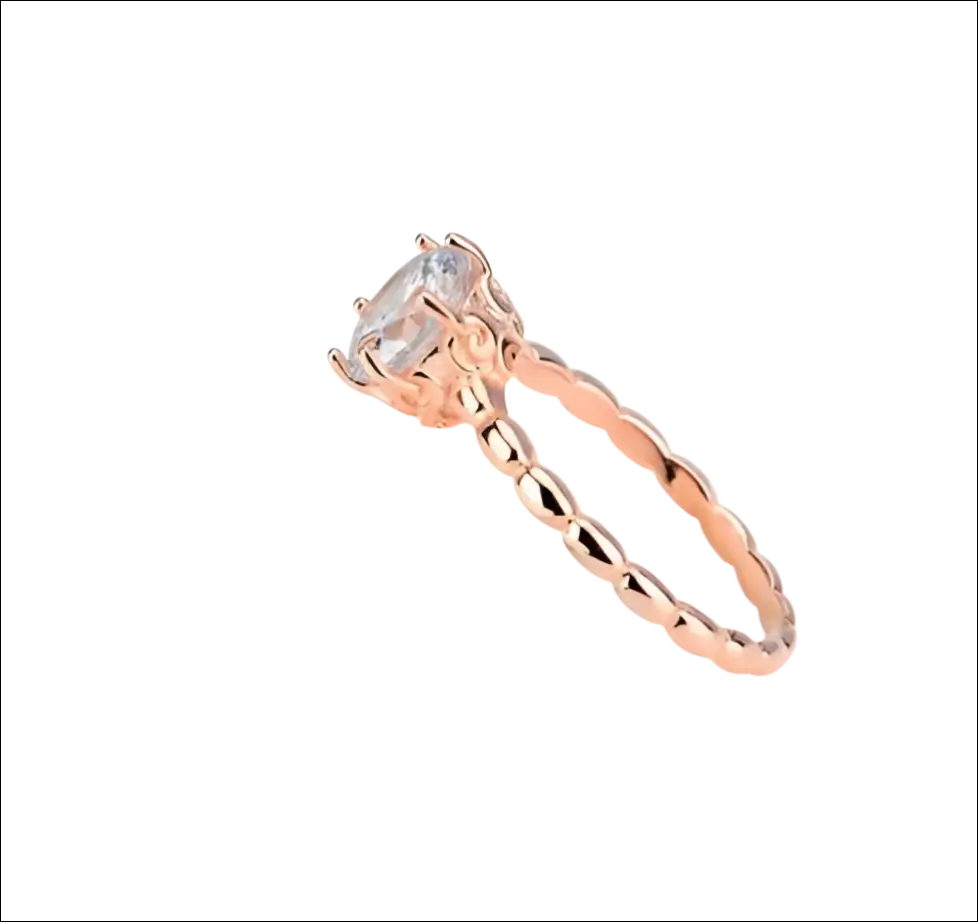 Rose gold beaded sterling silver ring with a faceted clear round gemstone and ornate textured silver ring band