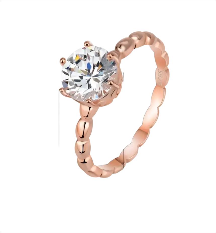 Rose gold beaded sterling silver ring with a round-cut clear gemstone set in four prongs and ornate band