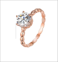 Rose gold beaded sterling silver ring with a round-cut clear gemstone set in four prongs and ornate band
