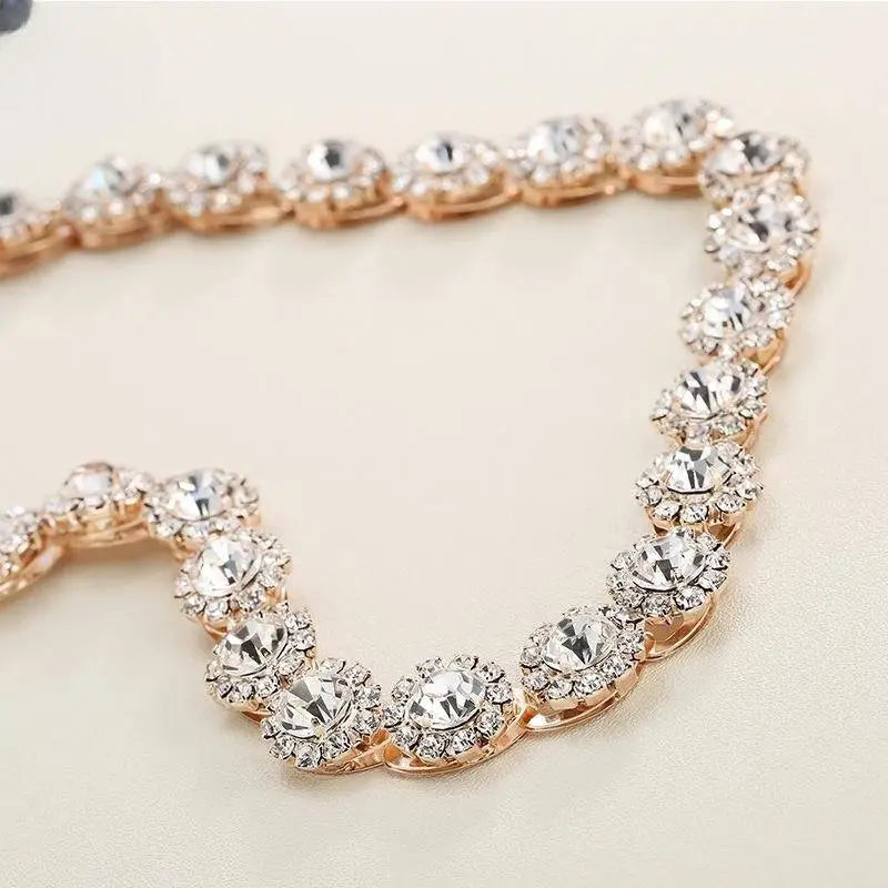 A delicate rose gold bridal rhinestone sunflower hair band adorned with clear sparkling crystals for weddings