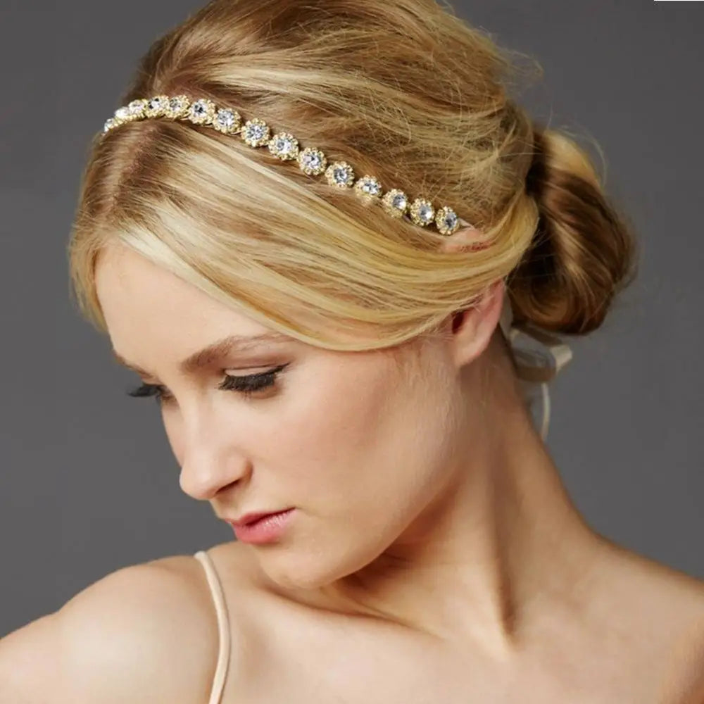 A delicate gold bridal rhinestone sunflower hair band with clear crystals in ornate floral designs for bridal wear