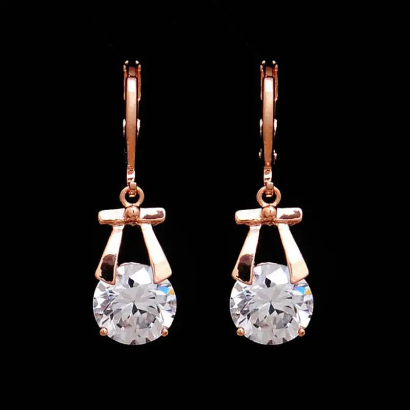 Rose gold hoop earrings with bow-shaped frame and clear crystal paired with gold-plated butterfly pendant bride necklace