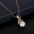 A rose gold pearl necklace earrings bridal set featuring a delicate necklace with a white pearl and leaf charms