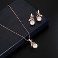 Rose gold pearl necklace earrings bridal set with delicate leaf designs cradling round white pearls