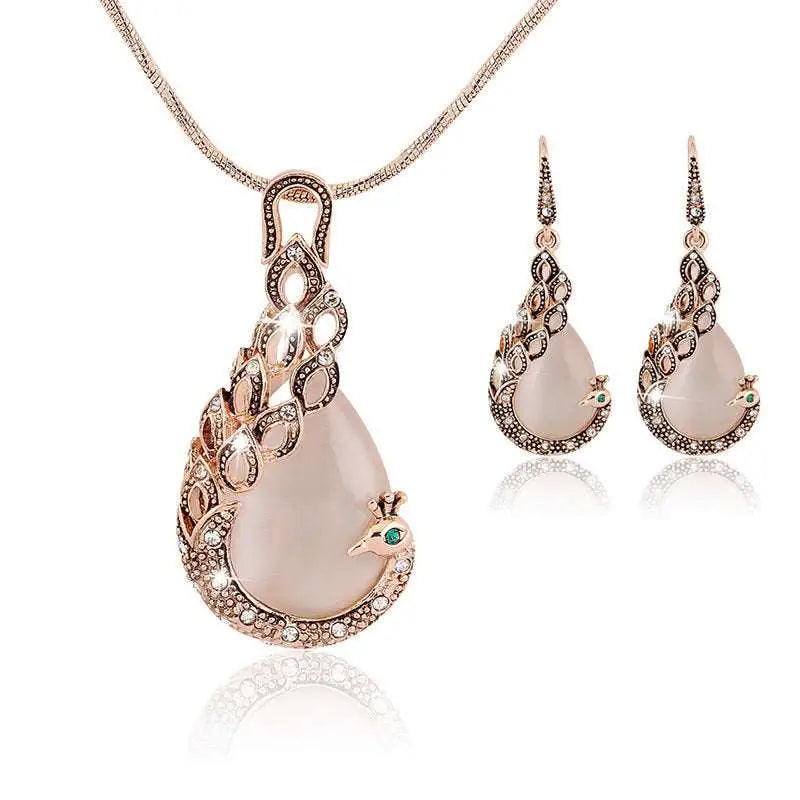 Rose gold rose pink jade peacock jewelry set featuring a pendant necklace with rhinestone detailing and matching drop earrings