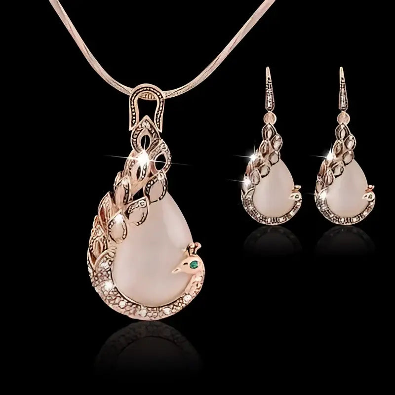 Elegant rose gold peacock jewelry set with pink jade stones, crystal feather detailing, and green gemstone accents