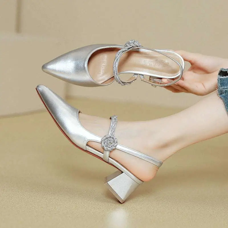 Silver metallic pointed-toe mules with crystal-embellished ankle strap and block heel complement rose gold satin chunky heel designs