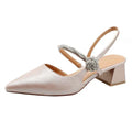 A shimmering silver metallic pointed toe slingback pump with chunky heel and glittering floral embellishment on strap
