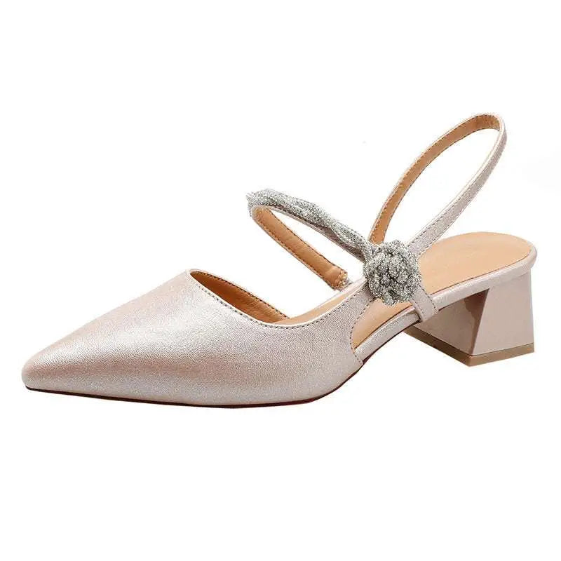 A shimmering silver metallic pointed toe slingback pump with chunky heel and glittering floral embellishment on strap