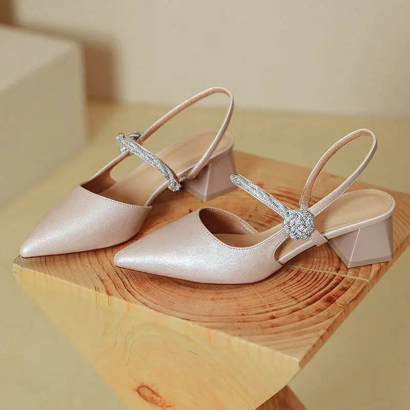 Rose gold satin pointed toe high heels with chunky heel and shimmering crystal buckle on satin slingback straps