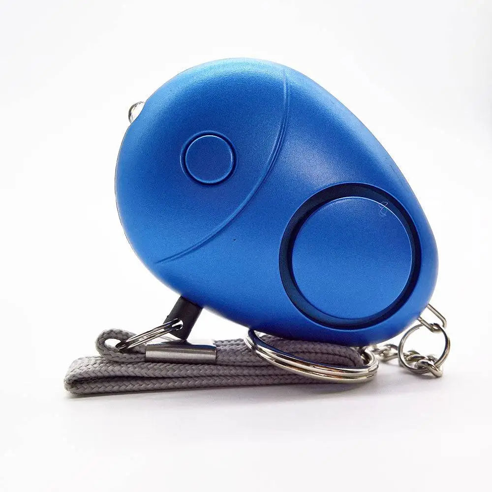 Blue egg-shaped personal security alarm with textured surface, circular button, speaker, gray strap, and metal keychain