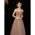 A golden suspender dress female dinner featuring a shimmering rose gold sequin bodice and flowing champagne tulle skirt